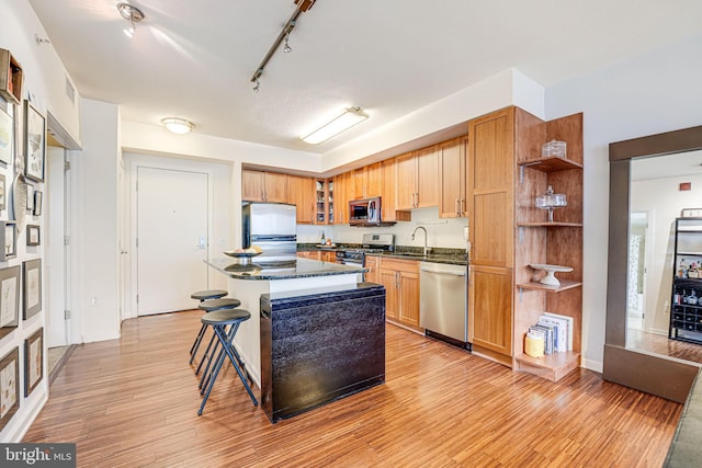 440 L St NW Unit 513, Washington, DC 20001 - kitchen with open shelves, a sink, light wood finished floors, appliances with stainless steel finishes, and a kitchen island