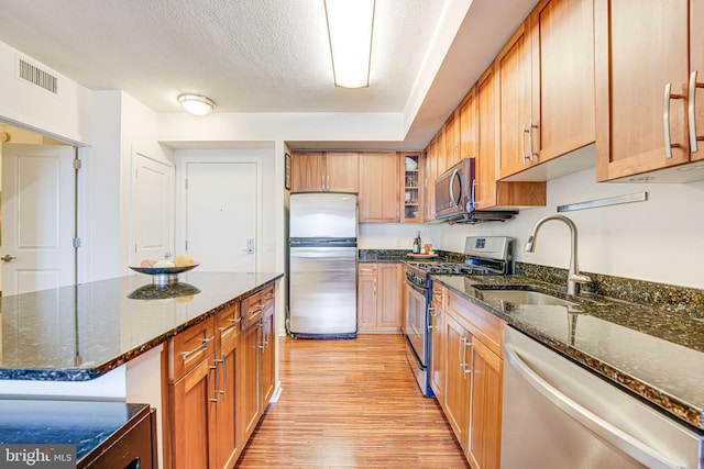 440 L St NW Unit 513, Washington, DC 20001 - kitchen featuring dark stone counters, appliances with stainless steel finishes, a sink, and light wood-type flooring