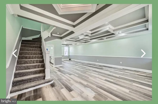 below grade area with stairs, wood finished floors, baseboards, and ornamental molding
