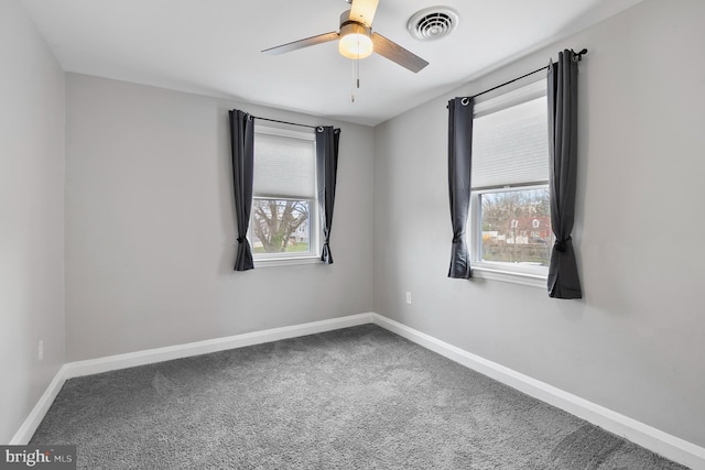unfurnished room with visible vents, baseboards, carpet, and ceiling fan