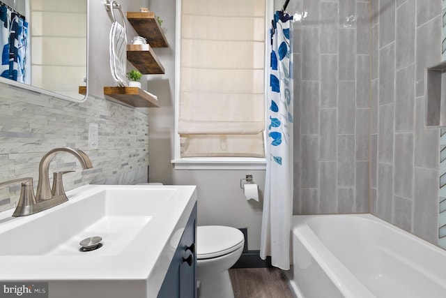 bathroom with vanity, wood finished floors, shower / bath combo, toilet, and backsplash
