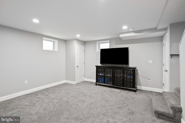 unfurnished living room with recessed lighting, baseboards, and carpet