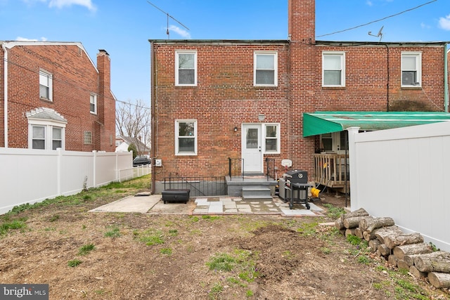 back of house featuring brick siding, a patio, and fence