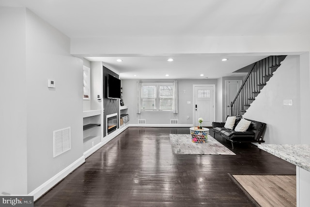 unfurnished living room featuring visible vents, baseboards, stairway, recessed lighting, and wood finished floors