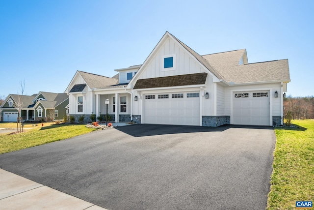 62 Serviceberry Dr, Zion Crossroads, VA 22942 - view of front facade featuring stone siding, aphalt driveway, a front lawn, and board and batten siding