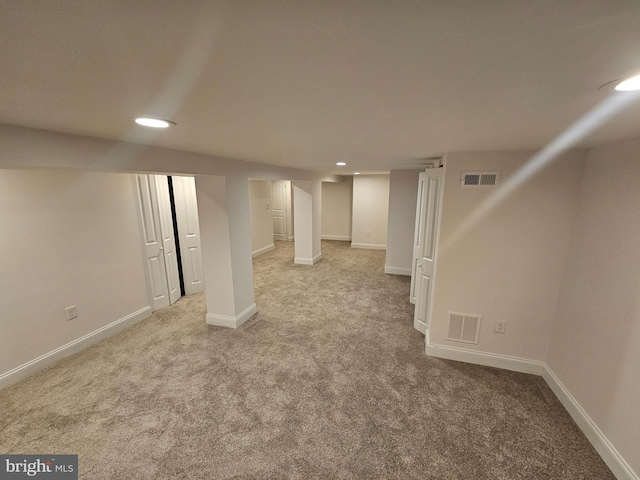 finished basement with recessed lighting, visible vents, baseboards, and light carpet