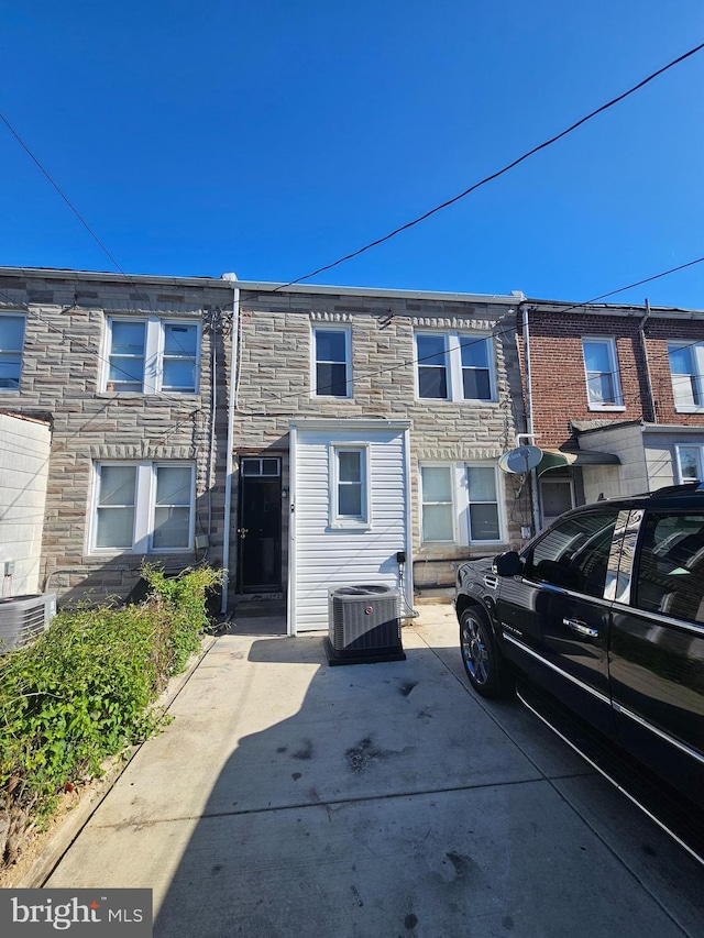 view of front of home with stone siding and central AC unit
