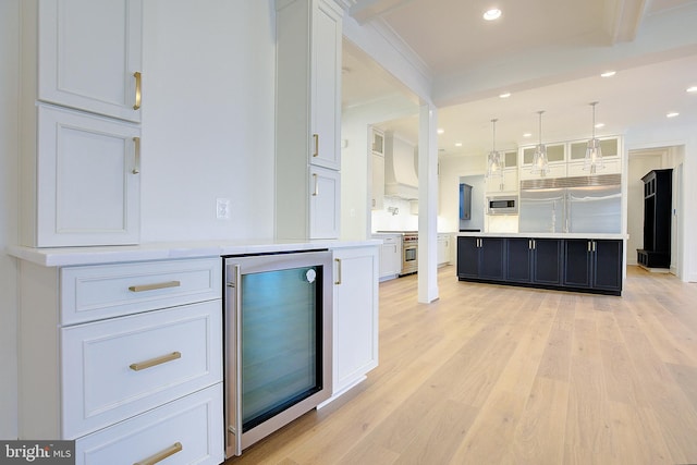 2762A Bon Haven Ln, Annapolis, MD 21401 - kitchen with custom exhaust hood, white cabinets, built in appliances, light countertops, and beverage cooler