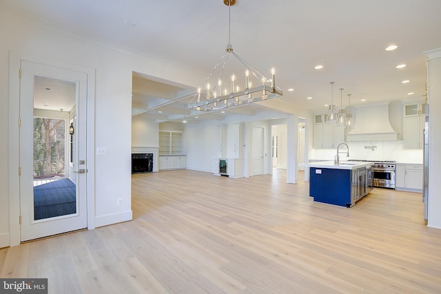 2762A Bon Haven Ln, Annapolis, MD 21401 - kitchen with custom exhaust hood, white cabinets, an inviting chandelier, open floor plan, and light countertops