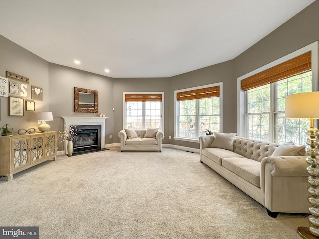living room with carpet floors, a fireplace with flush hearth, baseboards, and recessed lighting