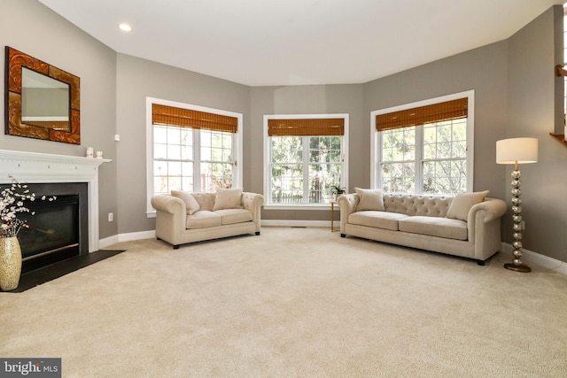 living room with baseboards, carpet floors, a fireplace with flush hearth, and recessed lighting