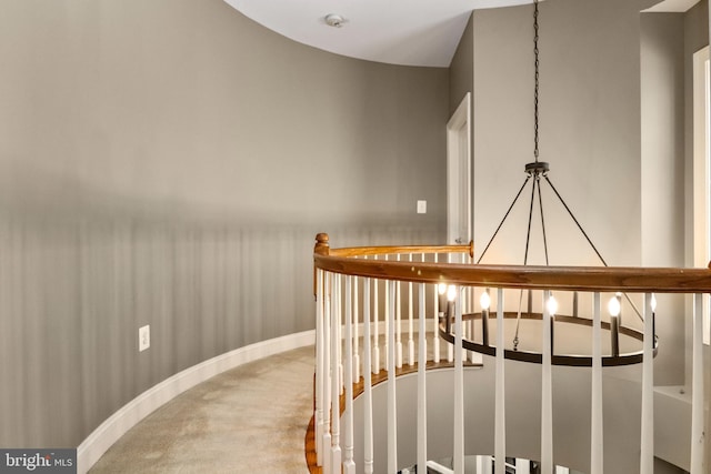 stairs with baseboards, a notable chandelier, and carpet