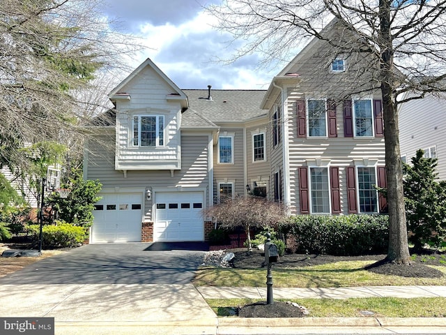 view of front of property with driveway, an attached garage, and roof with shingles