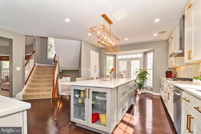 kitchen featuring a wealth of natural light, light countertops, a kitchen bar, and stainless steel appliances