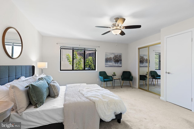 carpeted bedroom featuring baseboards, multiple windows, a closet, and ceiling fan