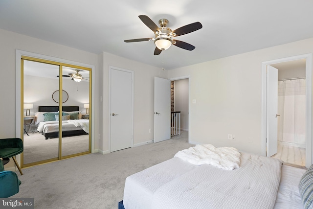 bedroom with baseboards, ensuite bathroom, a ceiling fan, and light colored carpet
