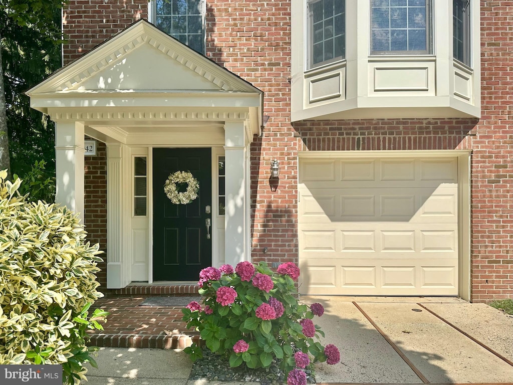 4042 Werthers Ct, Fairfax, VA 22030 - property entrance with a garage, brick siding, and concrete driveway