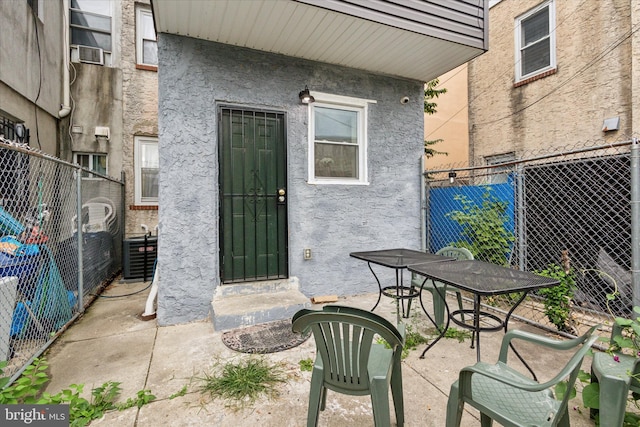 1557 N 9th St, Philadelphia, PA 19122 - entrance to property featuring a patio area, fence, central AC unit, and stucco siding