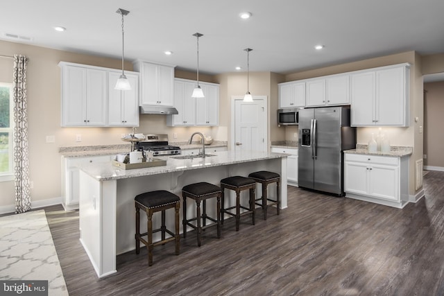 kitchen with visible vents, under cabinet range hood, appliances with stainless steel finishes, white cabinets, and a sink