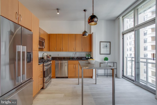 811 4th St NW Unit 608, Washington, DC 20001 - kitchen with appliances with stainless steel finishes, light wood-style floors, a sink, dark countertops, and decorative light fixtures