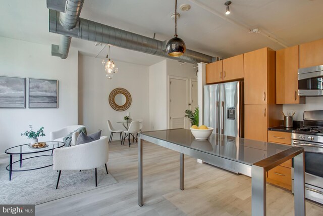 811 4th St NW Unit 608, Washington, DC 20001 - kitchen featuring appliances with stainless steel finishes, dark countertops, light wood-type flooring, and hanging light fixtures