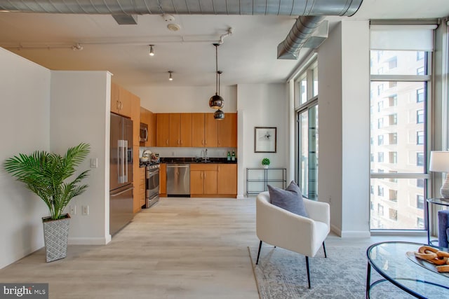 811 4th St NW Unit 608, Washington, DC 20001 - kitchen featuring stainless steel appliances, dark countertops, a sink, light wood-style flooring, and track lighting