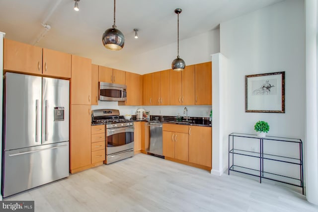 811 4th St NW Unit 608, Washington, DC 20001 - kitchen featuring appliances with stainless steel finishes, dark countertops, a sink, and light wood finished floors