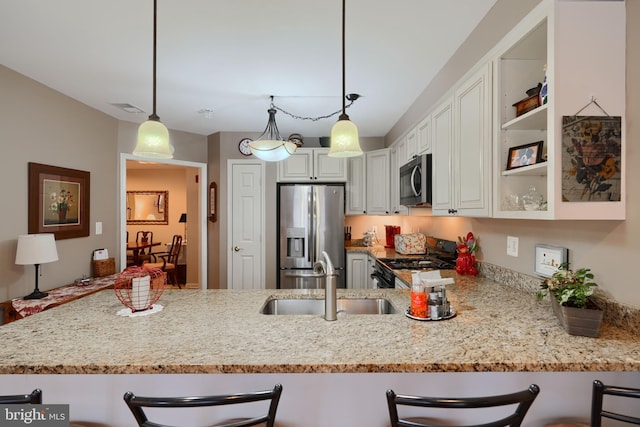 kitchen with stainless steel appliances, a sink, light stone counters, and a breakfast bar area