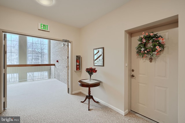 carpeted foyer entrance with baseboards