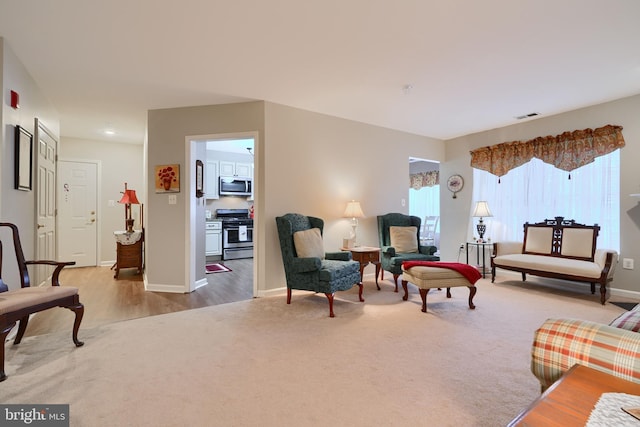 carpeted living room featuring baseboards, wood finished floors, and recessed lighting