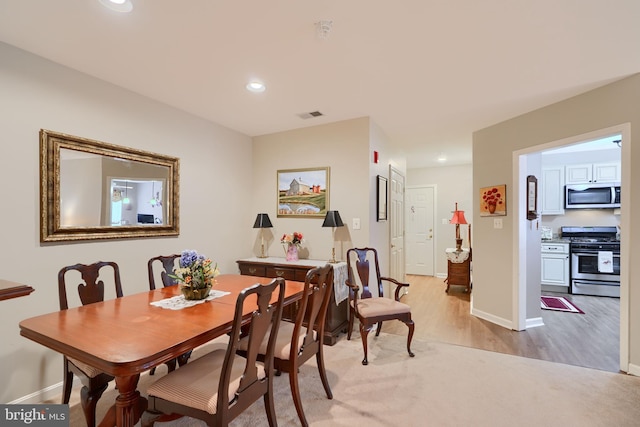 dining area with light wood-type flooring, baseboards, and recessed lighting