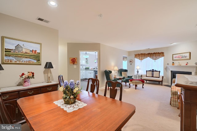 dining area with light carpet, recessed lighting, and a fireplace