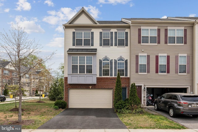 view of property with an attached garage, driveway, and brick siding
