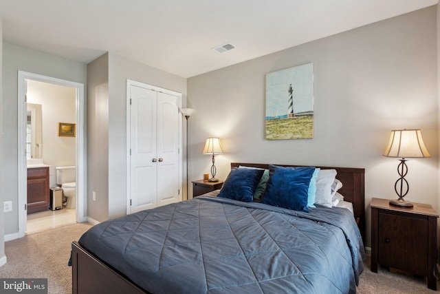 carpeted bedroom with baseboards, visible vents, ensuite bathroom, and a closet