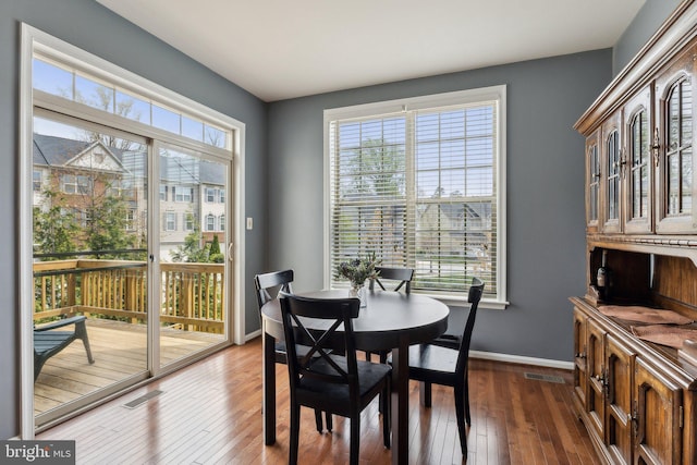 dining room with baseboards, visible vents, and hardwood / wood-style floors