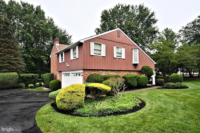 40 Brookside Dr, Holland, PA 18966 - view of home's exterior with brick siding, a chimney, asphalt driveway, a garage, and a lawn