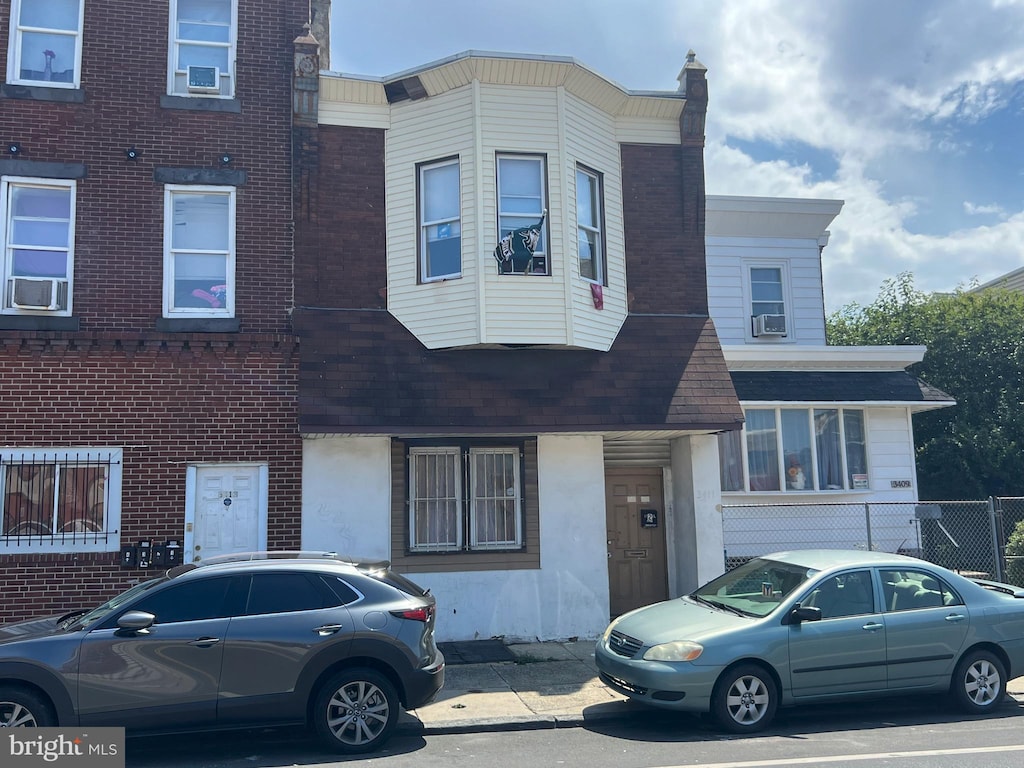 townhome / multi-family property featuring a chimney, cooling unit, and brick siding