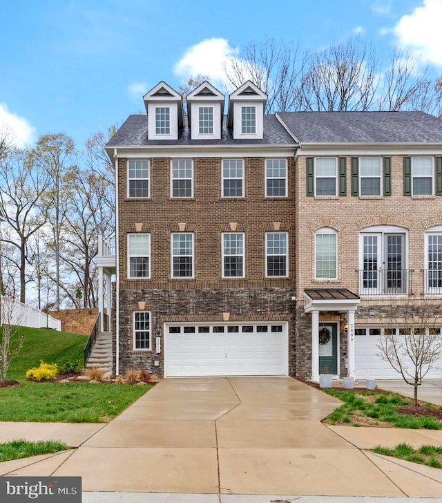 view of front of home featuring stone siding, brick siding, concrete driveway, and an attached garage