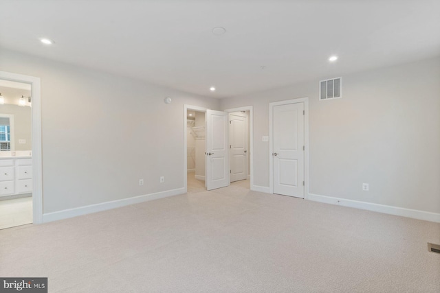 unfurnished bedroom featuring baseboards, visible vents, recessed lighting, and light carpet