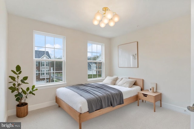 bedroom featuring baseboards, a notable chandelier, and carpet