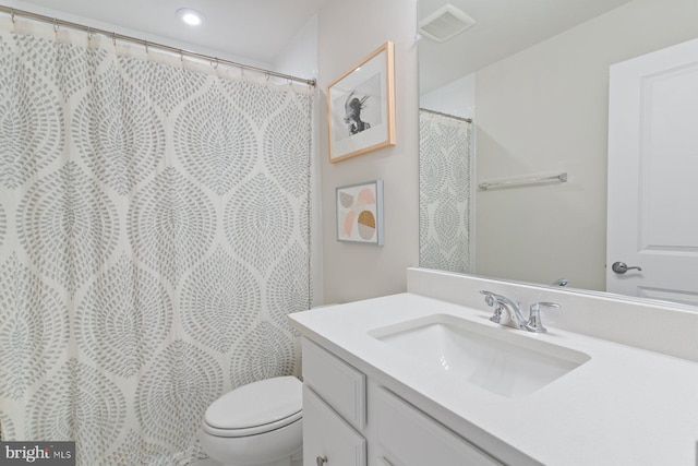bathroom featuring visible vents, toilet, and vanity