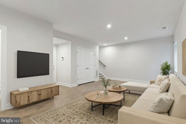 living area with recessed lighting, stairs, visible vents, and light wood-style floors