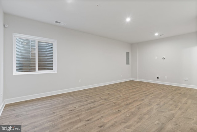 spare room with light wood-type flooring, baseboards, and visible vents
