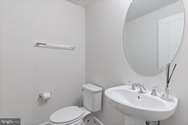 bathroom featuring baseboards, a sink, and toilet