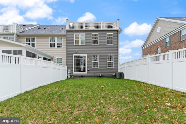 back of property featuring a fenced backyard, central AC, and a yard