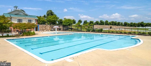 view of swimming pool featuring fence