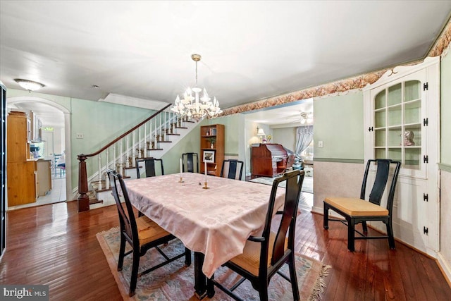dining space with arched walkways, stairs, hardwood / wood-style floors, and a wealth of natural light