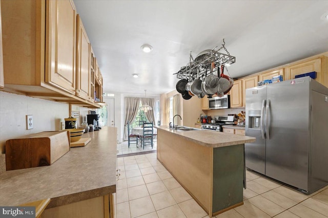 kitchen featuring a kitchen island with sink, stainless steel appliances, light tile patterned floors, and a sink
