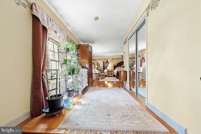 hallway featuring light wood-style floors and baseboards