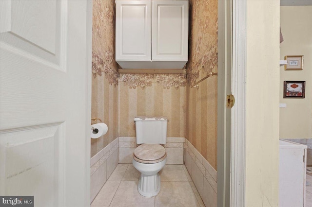 bathroom with tile patterned flooring, wallpapered walls, and toilet